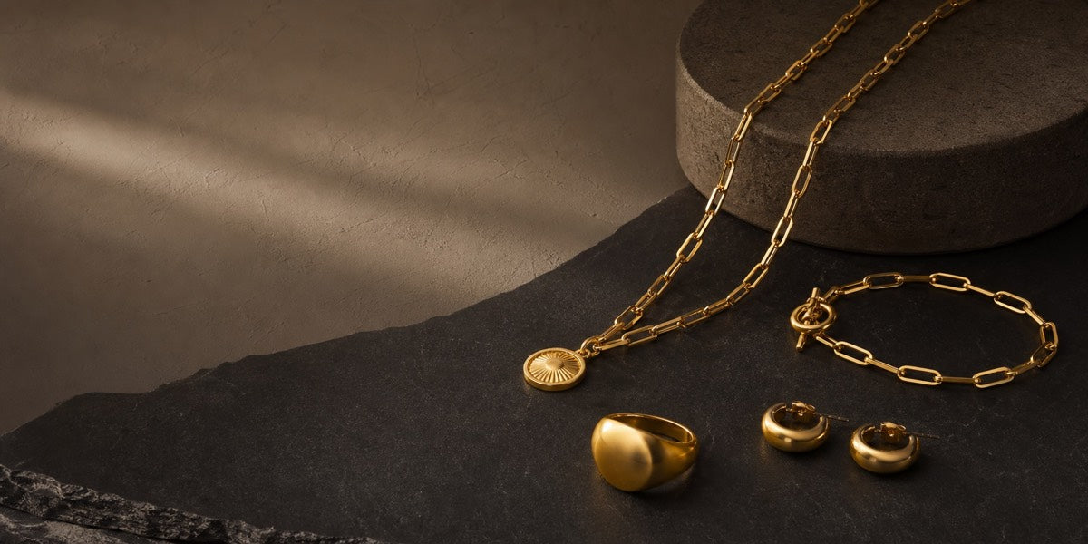 A layered GILDROW jewelry edit on dark stone