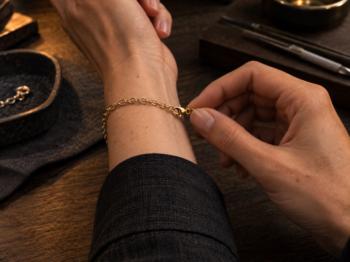 A fine gold bracelet being fastened around a wrist