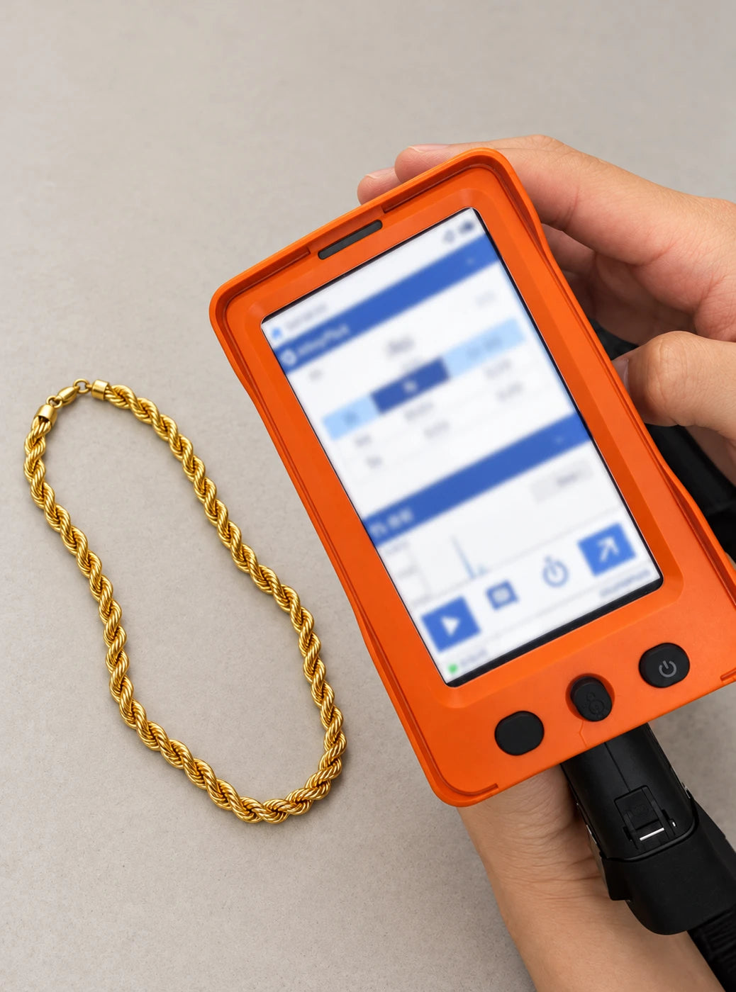 Illustrative inspection scene with a gold rope chain and handheld analyzer
